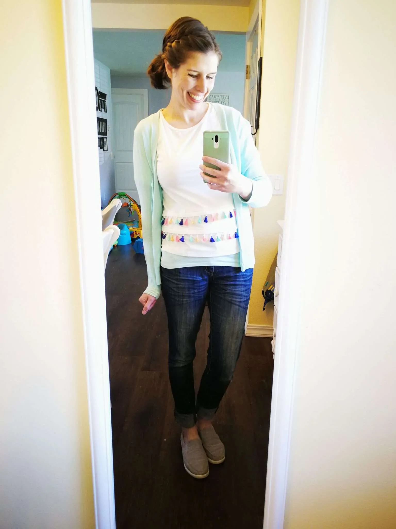 T-shirt with colorful tassels untucked with skinny jeans.