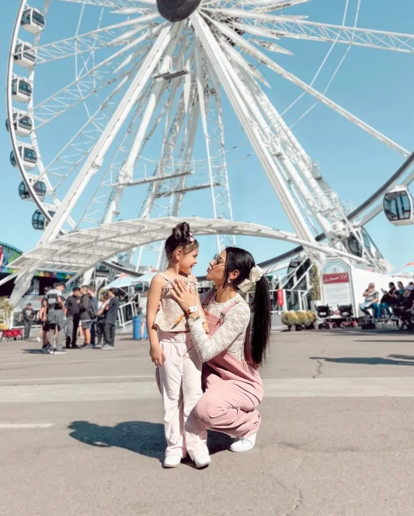 A dreamy aesthetic mommy and me outfit for the fair. Mom stuns in dusty pink overalls layered with a lace top, while her daughter wears matching tones. Perfect for feminine photo moments at a summer carnival.