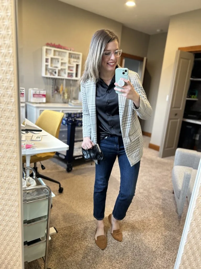 Woman styling straight leg jeans with plaid blazer and black blouse, smiling in mirror. Text: 10 Easy Fall Outfits.
