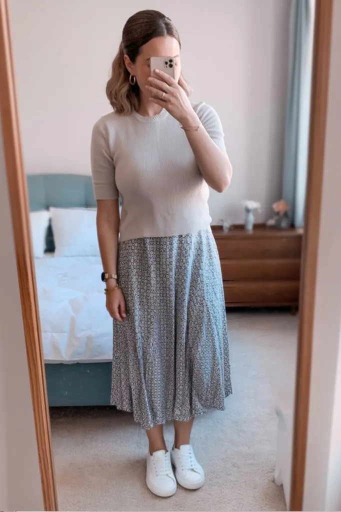 Teacher wearing printed midi skirt with ivory sweater and sneakers styled for comfort and movement.