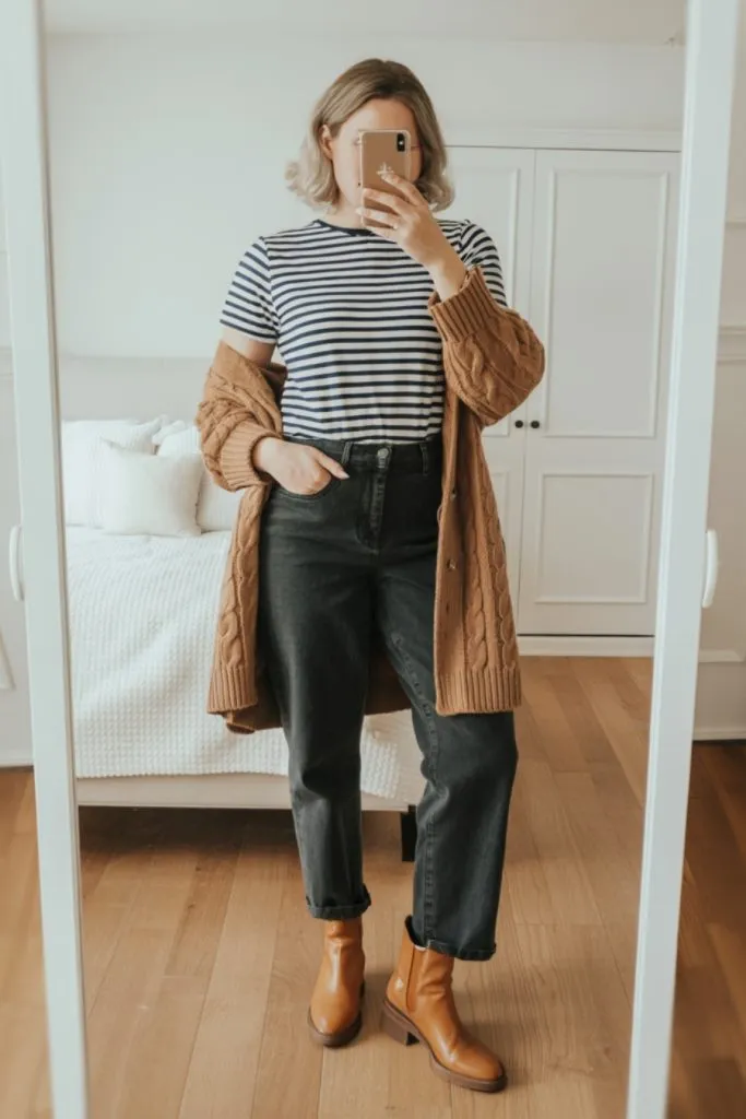 Woman wearing striped tee, camel cardigan, jeans, and ankle boots for everyday fall outfit.