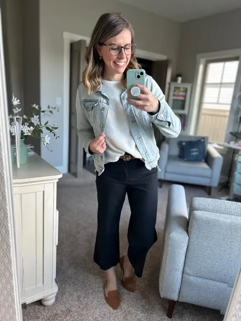 Woman wearing black cropped pants with a white tee and denim jacket in a mirror selfie