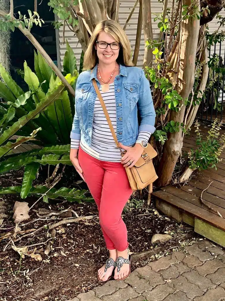 Woman wearing red pants with a striped shirt and denim jacket outdoors