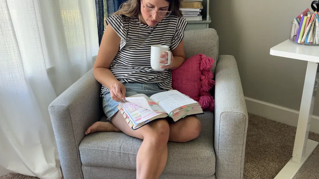 Woman reading book with coffee, showing how getting dressed saves time for busy moms